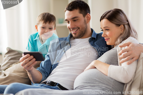 Image of happy family with smartphone at home