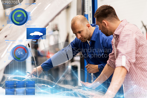 Image of auto mechanic with clipboard and man at car shop