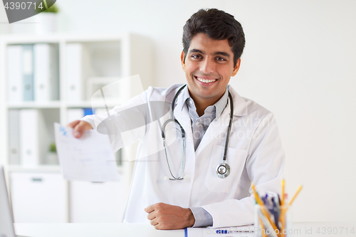 Image of happy doctor with prescription at clinic