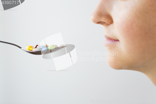 Image of close up of female face and spoon with pills