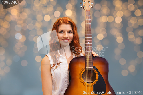 Image of female musician with guitar over lights background
