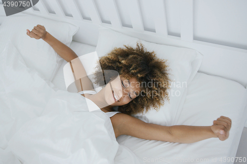 Image of Content woman awakening in bed