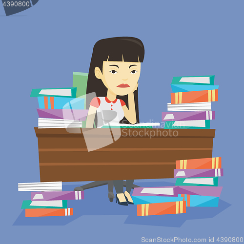 Image of Student sitting at the table with piles of books.