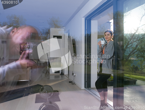 Image of woman drinking coffee in front of her luxury home villa