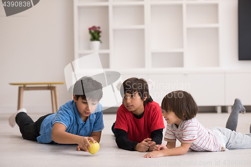 Image of boys having fun with an apple on the floor