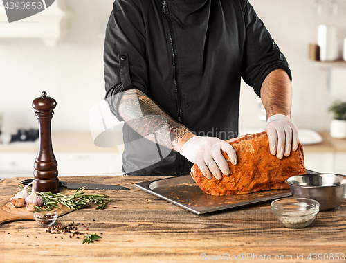 Image of Man cooking meat steak on kitchen