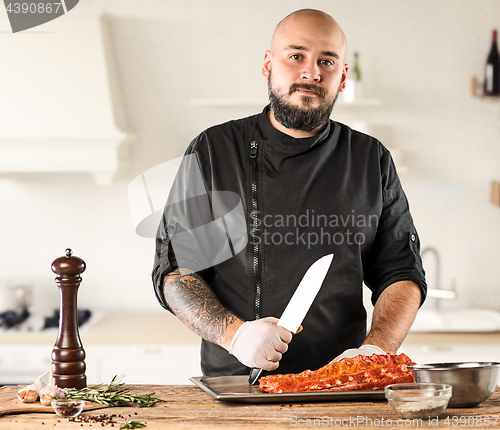 Image of Man cooking meat steak on kitchen