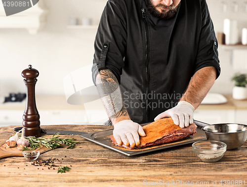 Image of Man cooking meat steak on kitchen