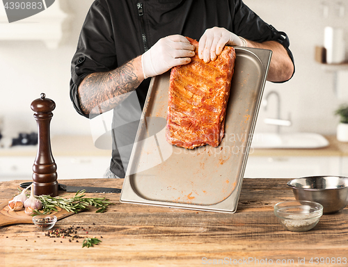 Image of Man cooking meat steak on kitchen