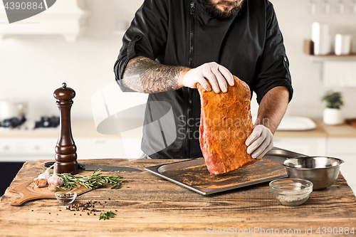 Image of Man cooking meat steak on kitchen