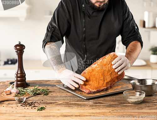 Image of Man cooking meat steak on kitchen