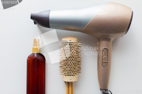 Image of hairdryer, brush and hot styling hair spray