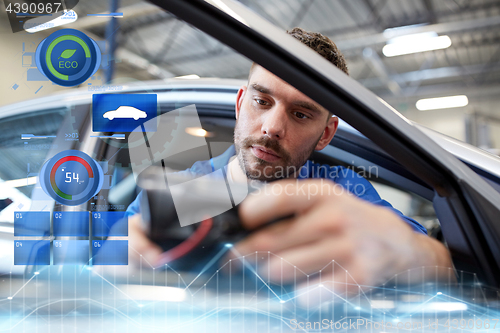 Image of mechanic man with diagnostic scanner at car shop