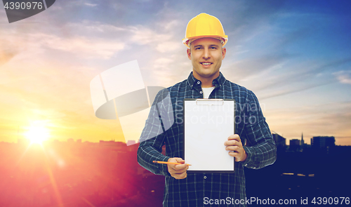 Image of male builder in yellow hard hat with clipboard