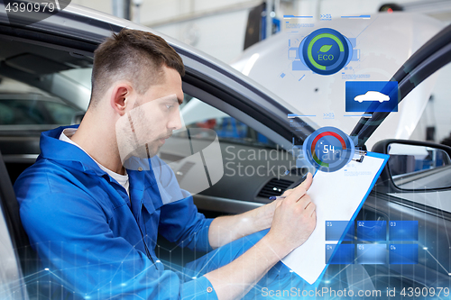 Image of auto mechanic man with clipboard at car workshop