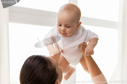 Image of happy mother playing with little baby boy at home