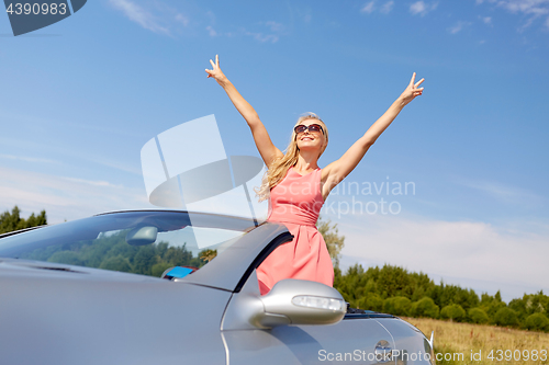 Image of happy young woman in convertible car