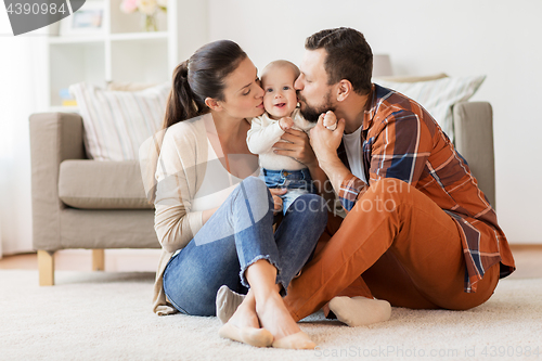 Image of happy mother and father kissing baby at home