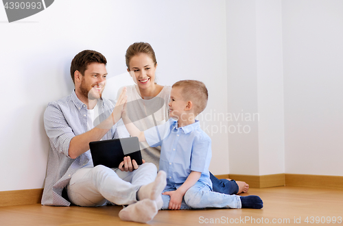 Image of family with tablet pc at new home making high five