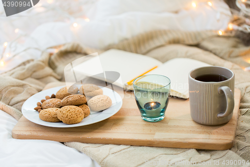 Image of cookies, tea and candle in holder at home