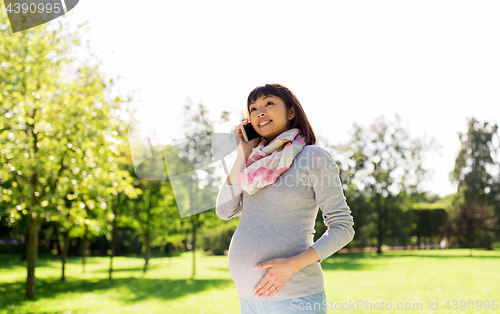 Image of pregnant asian woman calling on smartphone at park