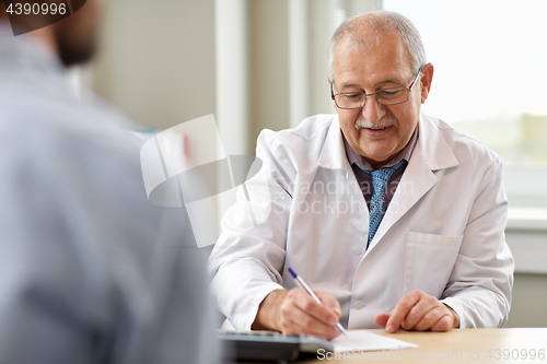 Image of doctor writing prescription for patient at clinic