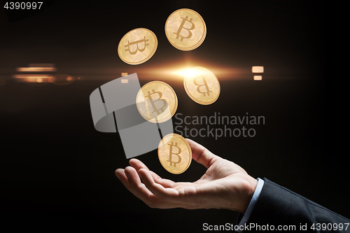 Image of close up of businessman hand with bitcoins