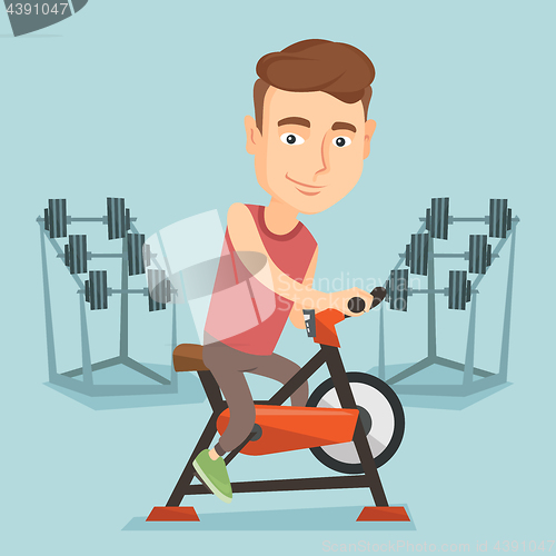 Image of Young man riding stationary bicycle.
