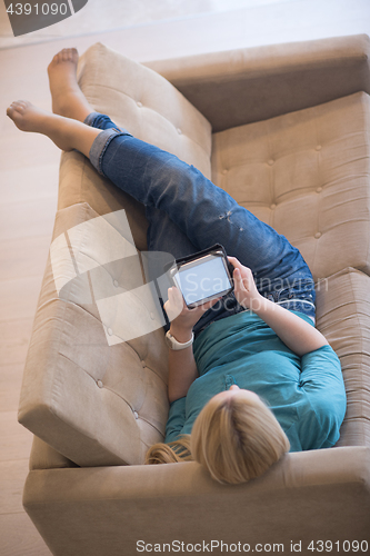 Image of woman on sofa using tablet computer