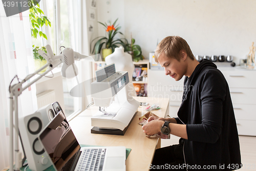 Image of fashion designer with sewing machine at studio