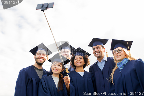 Image of group of happy students or graduates taking selfie