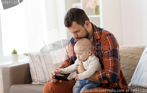 Image of father and baby boy with smartphone at home