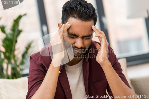 Image of unhappy man suffering from head ache at home