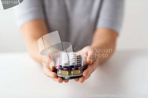 Image of woman hands holding packs of pills