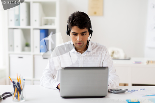 Image of businessman with headset and laptop at office