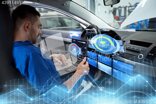 Image of mechanic man with laptop making car diagnostic