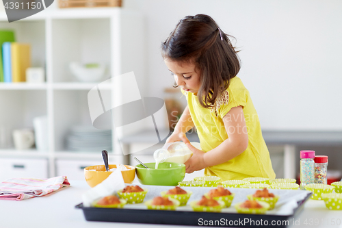 Image of little girl baking muffins at home