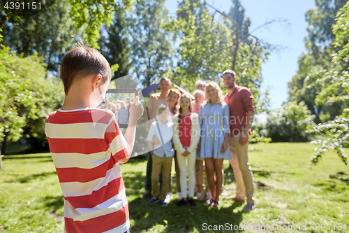 Image of happy family photographing by tablet pc in summer