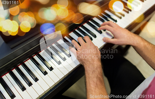 Image of close up of male hands playing piano