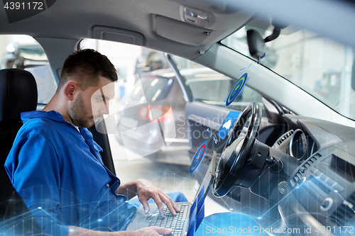 Image of mechanic man with laptop making car diagnostic