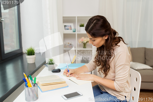 Image of female student with book learning at home