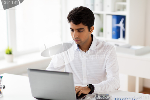 Image of businessman with laptop working at office