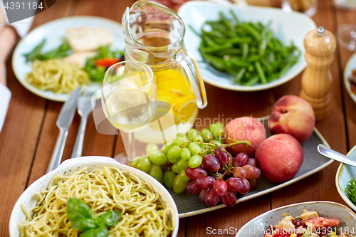 Image of fruits, salads and pasta on wooden table