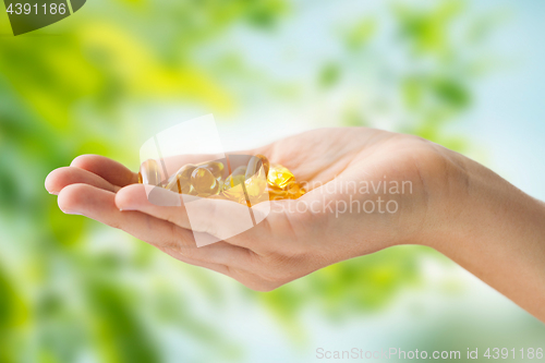 Image of hand holding cod liver oil capsules