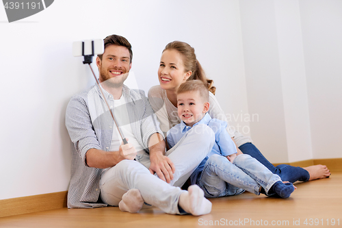 Image of family taking selfie by smartphone at new home