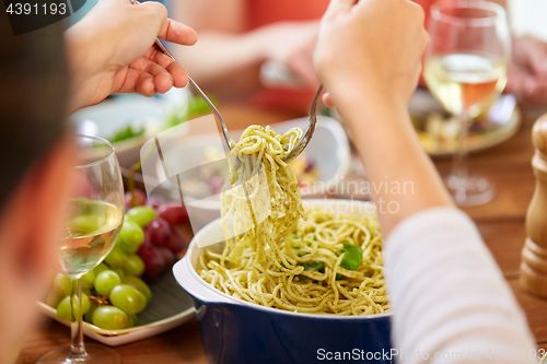 Image of pasta with basil in bowl and other food on table