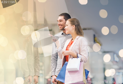 Image of happy young couple with shopping bags in mall