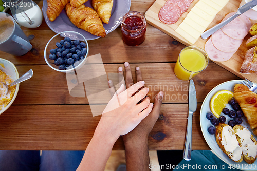 Image of couple hands on table full of food