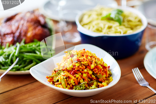 Image of vegetable salad with corn and other food on table