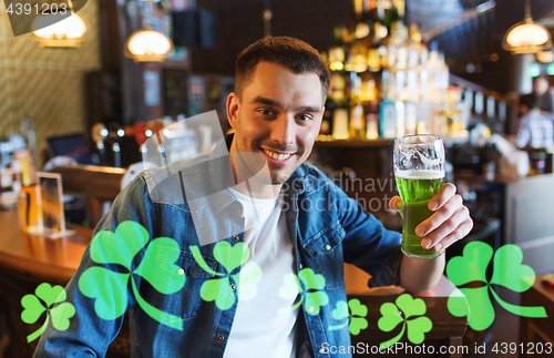 Image of man drinking green beer at bar or pub